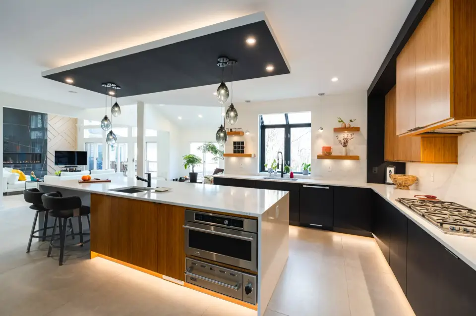The kitchen from the living side, under-cabinet light glowing along the island