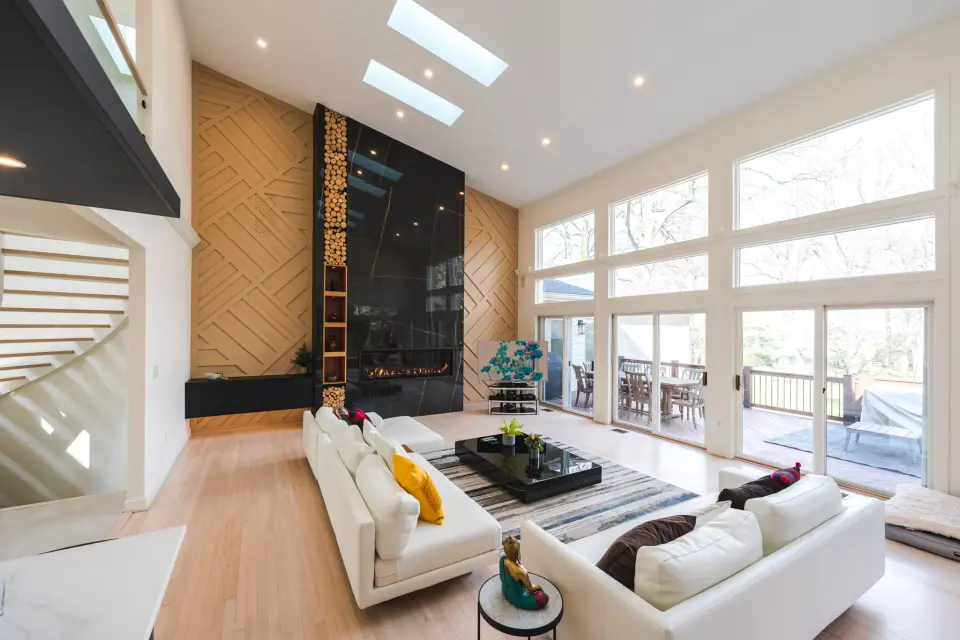Double-height living room with the black stone fireplace wall and a curved stair