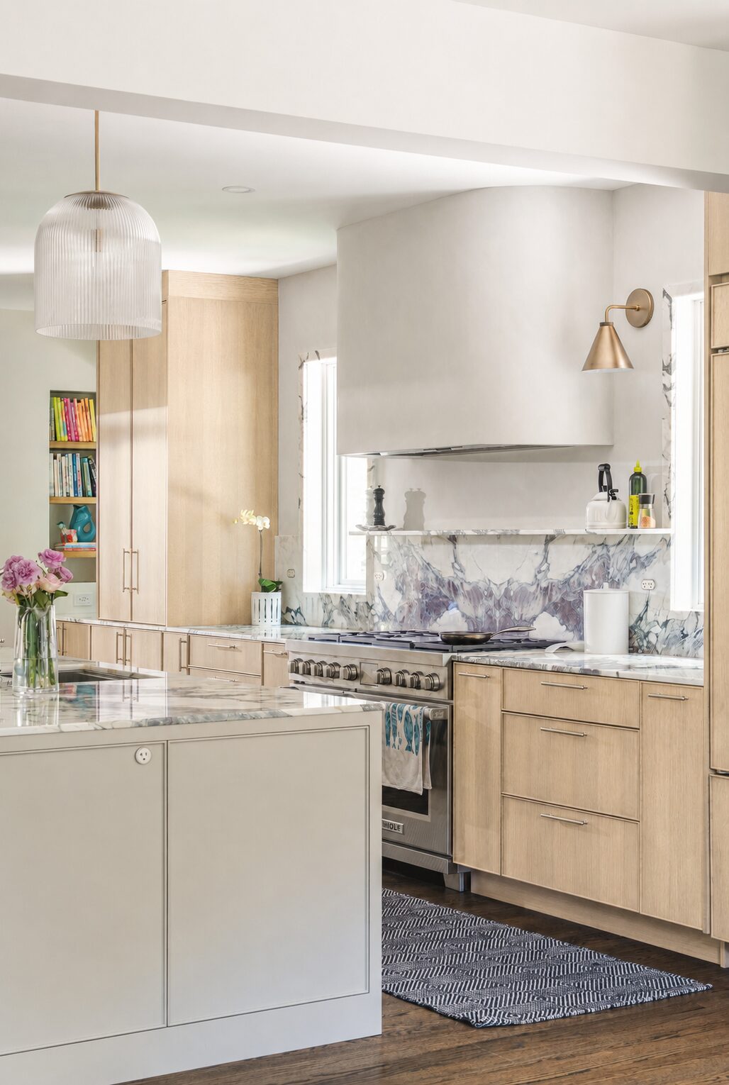 Light oak kitchen with a white hood and a marble backsplash