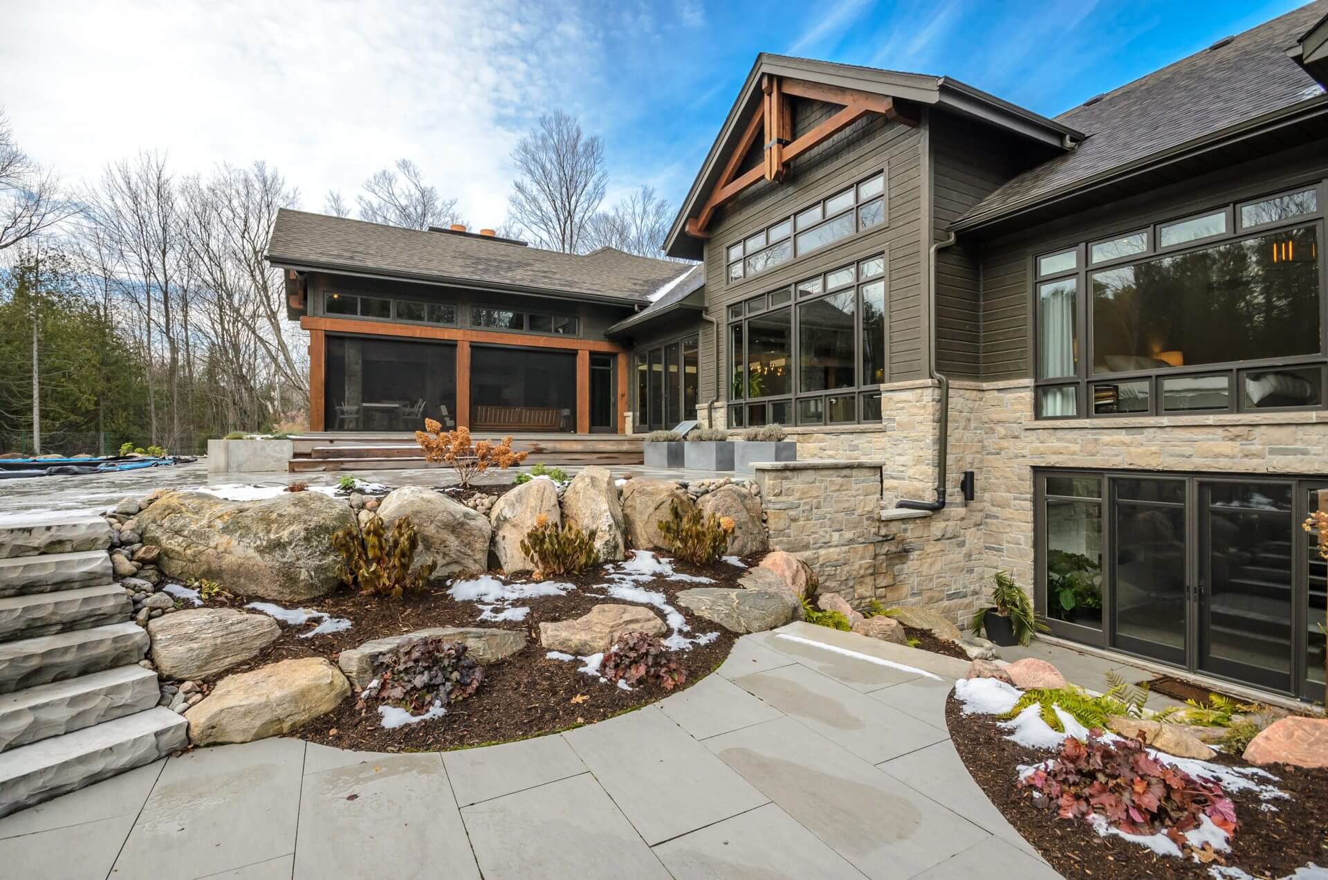 Craftsman house with a stone terrace and boulders